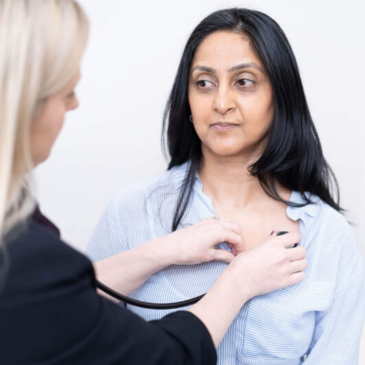 Femme se faisant écouter le cœur avec un stéthoscope