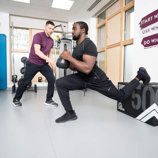 two men working out in a gym setting